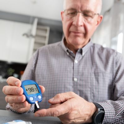 senior man controlling his diabetic retinopathy by checking his blood sugar