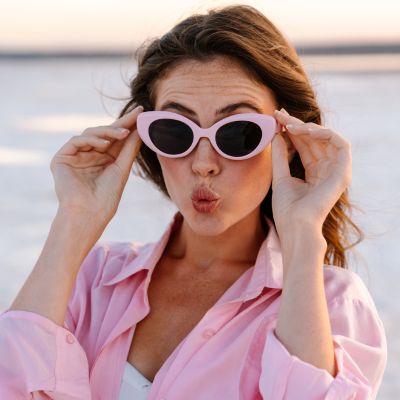 Shocked young girl in sunglasses posing at the beach