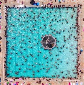 top-down image of people in a square-shaped public swimming pool