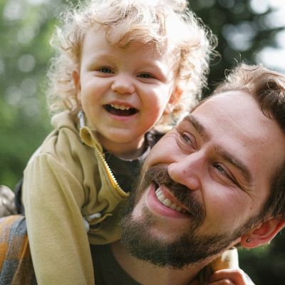 Father carrying his young son on his back.