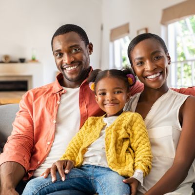 mother and father sitting with their young daughter