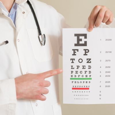 Eye doctor holding up a vision chart