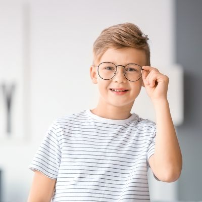 little boy wearing his new glasses at home after his back-to-school eye exam