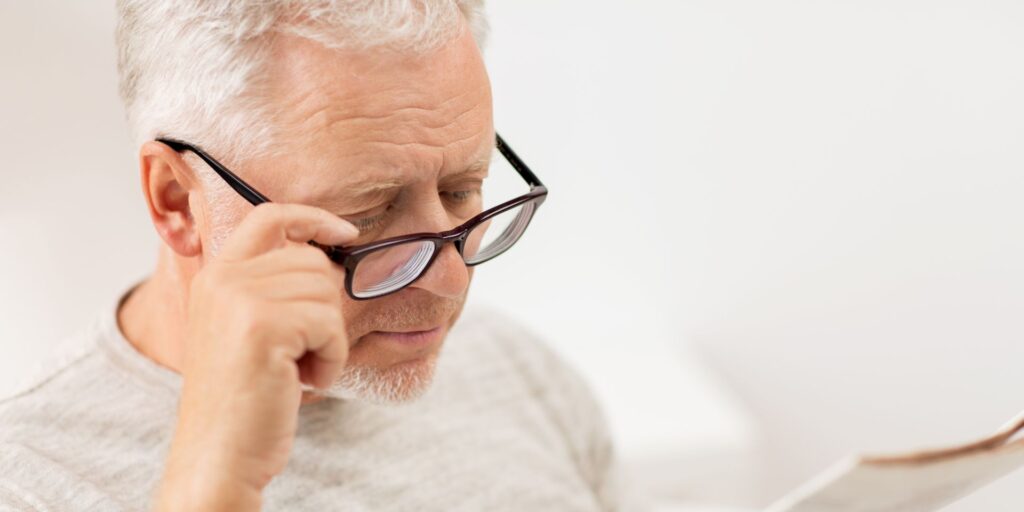 man wearing readers to read