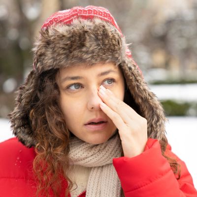 woman with a stuffy nose outside on a winter day