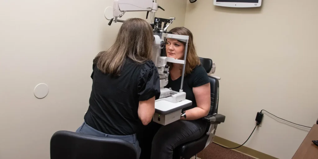 optometrist examines the eyes of a young woman patient with a photoroptor